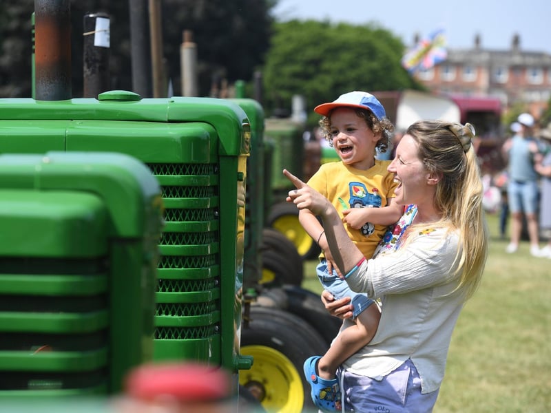 Sammie-Jo Hold with her son Magnus (aged three) looking at the tractors in the sunshine at Newby Hall