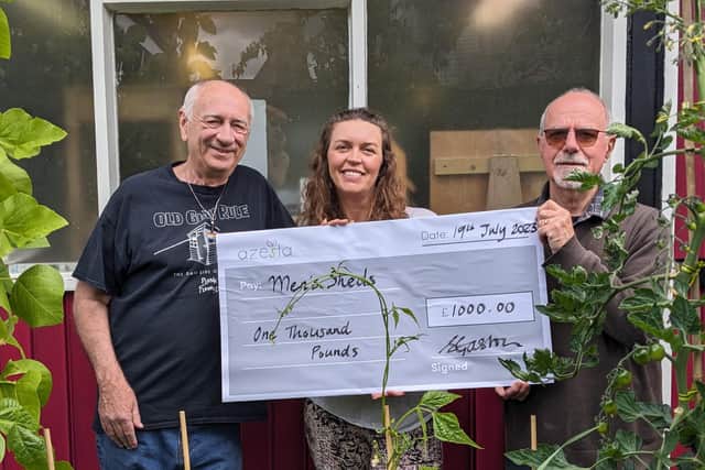 Kevin Murgatroyd and Alan Cottrill are presented a cheque of £1000 by Shirley Gaston, founder of Azesta.