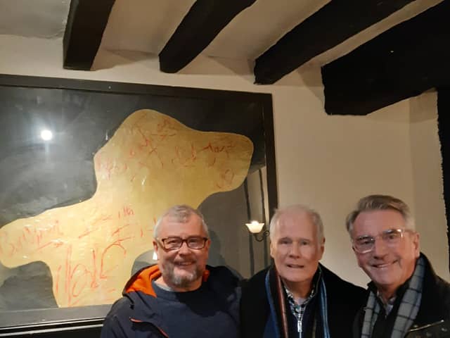 Rock n roll holy grail - Harrogate man Bernard Higgins, middle, in the York pub with what may be the Rolling Stones' autographs on the wall behind him. Also pictured Graham Chalmers, left. (Picture contributed)