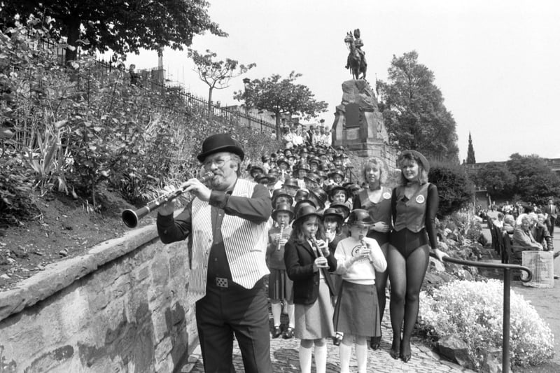 Jazz musician Acker Bilk does his Pied Piper impersonation with a clarinet when he leads Currie Primary School children through Princes Street gardens Edinburgh in June 1987.