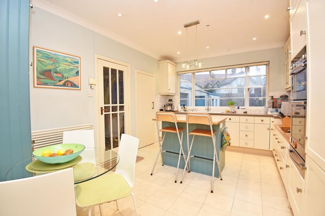 Within the well equipped kitchen is an island and breakfast bar. Appliances include an electric hob and double oven, an integrated dishwasher, fridge and freezer, and there is an inbuilt larder cupboard.