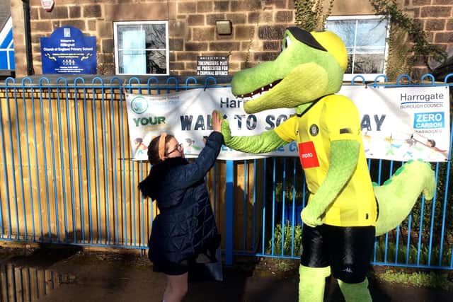 High five - A pupil from Killinghall C Of E Primary School with Harry Gator from Harrogate Town during a recent Harrogate Walk to School Day.