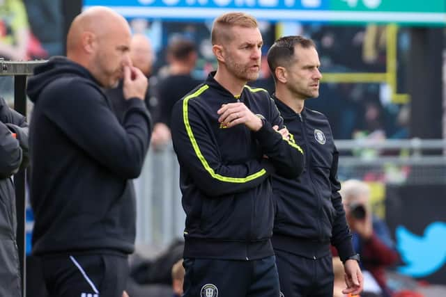 Harrogate Town boss Simon Weaver, centre, watches on from his technical area during Saturday's League Two win over Salford City.