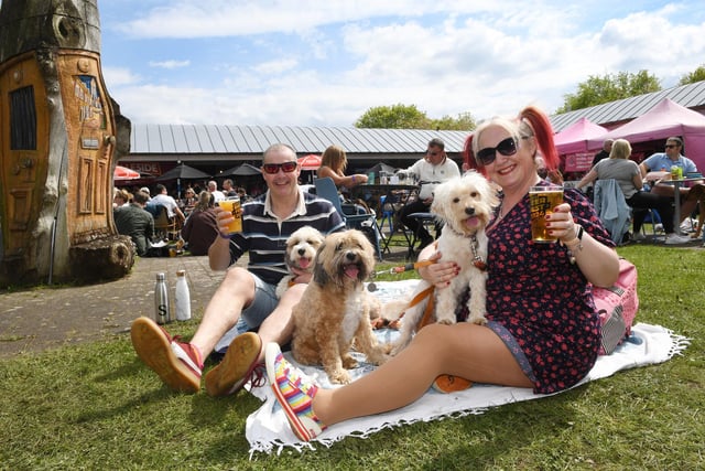 Amy Stobbs and David Stobbs with their dogs Poppy, Waffle and Cookie enjoying the sunshine and a pint at the festival