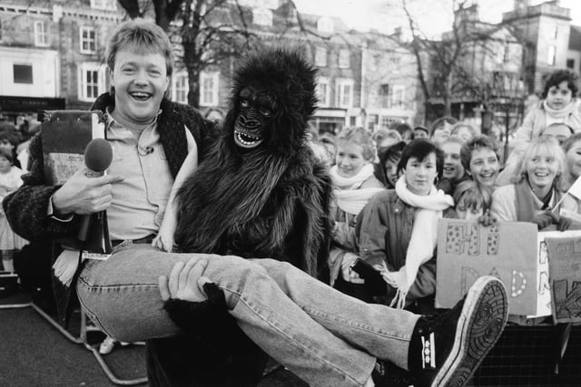 Saturday Superstore presenter Keith Chegwin gets a lift from ape man Jason Pitt during the BBC TV show's visit to Harrogate in 1985