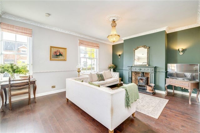 The stylish sitting room has a period fireplace with log burning stove, and engineered oak flooring, with many period decorative features.