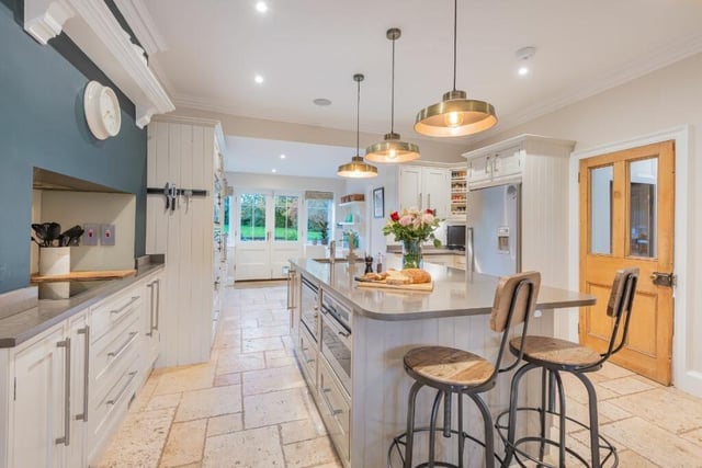 The kitchen with diner has hand-made cream cabinetry, with granite worktops and Smeg appliances.