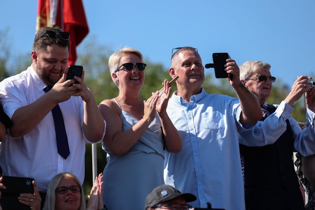 Members of the public take photos of their loved ones during the parade
