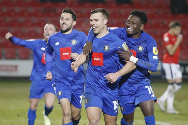 Jack Muldoon, centre, is congratulated by his Harrogate Town team-mates after opening the scoring during Tuesday evening's 1-1 League Two draw at Salford City.