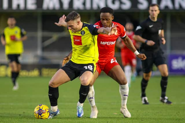 Jack Muldoon holds off Swindon defender Udoka Godwin-Malife.