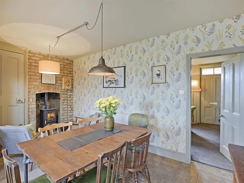 A spacious dining area with a warming stove in exposed brick surround.