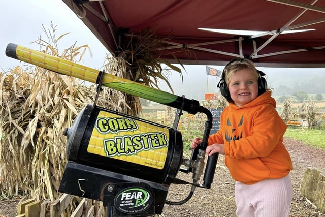 Pictured: A young girl having fun on the 'corn blaster' gun.