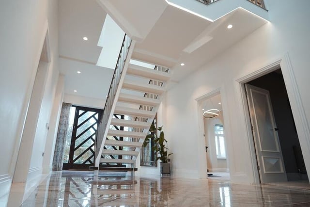 A gleaming hallway with feature open staircase leading up.