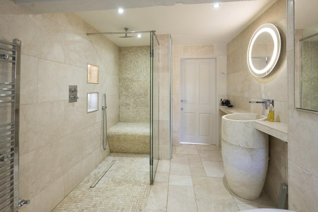 This tiled bathroom has a large, walk in shower facility.