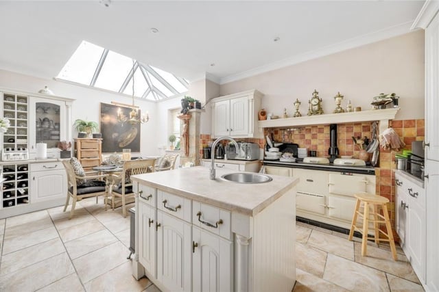 A well equipped dining kitchen with fitted units has an Aga and a central island unit.