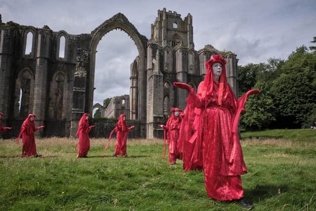 Surprise protest at historic site near Ripon - A procession by ‘The Red Rebels’ of Extinction Rebellion at Fountains Abbey on Saturday. (Picture Gerard Liston )