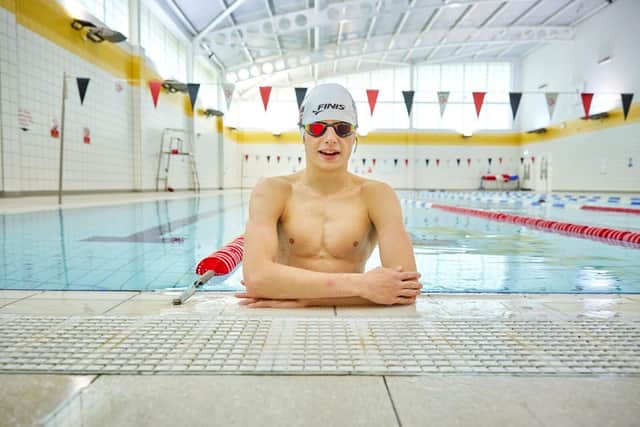 Archie at the side of a swimming pool looking at the camera