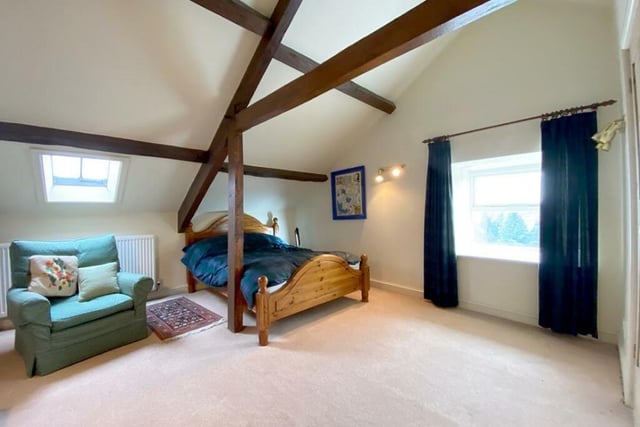 A second floor bedroom, with exposed beams to the ceiling.