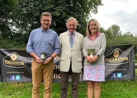 Masham GC Theakston Trophies winners Andrew Fallows, left, and Penny Nicklas, right, with Simon Theakston. Picture: Submitted