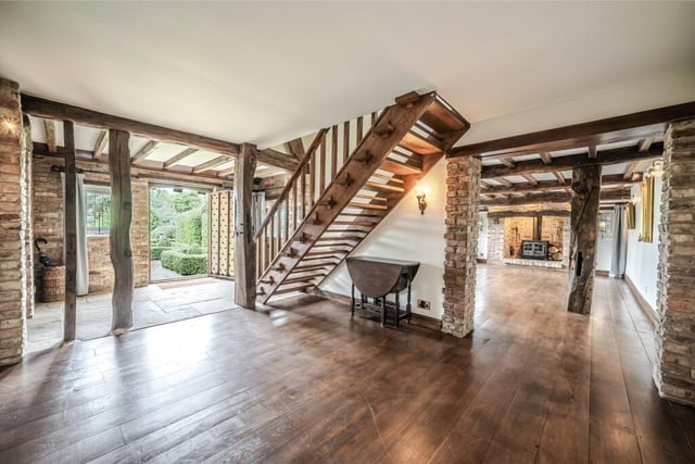 Beamed living space, with a staircase to the first floor.