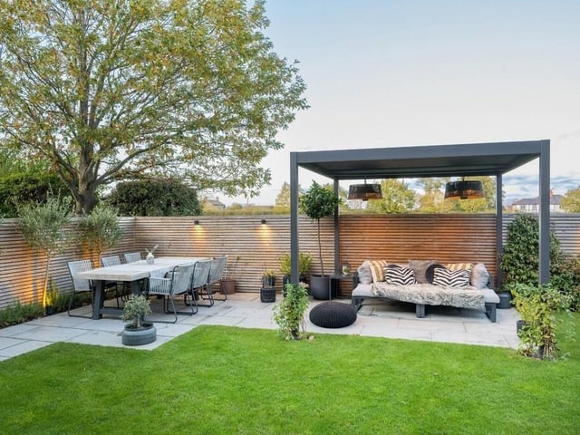 Patio seating areas with gazebo cover within the enclosed rear garden.