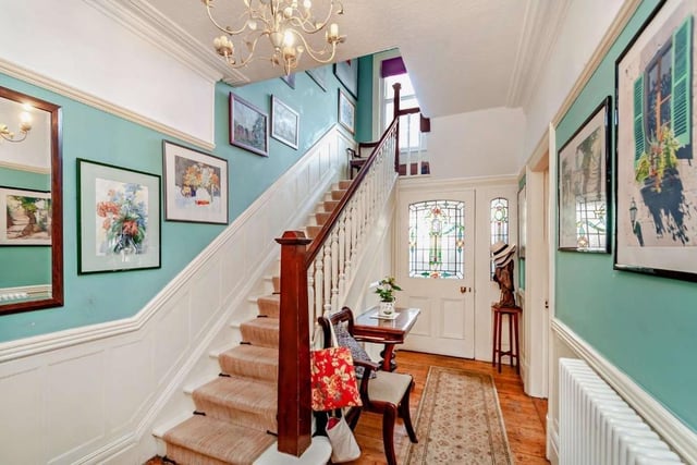 A door with stained glass panel opens in to the bright and welcoming hallway.