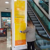 A member of the public using Harrogate District Street Aid ‘tap terminal’ at Victoria Shopping Centre to donate to the homeless.