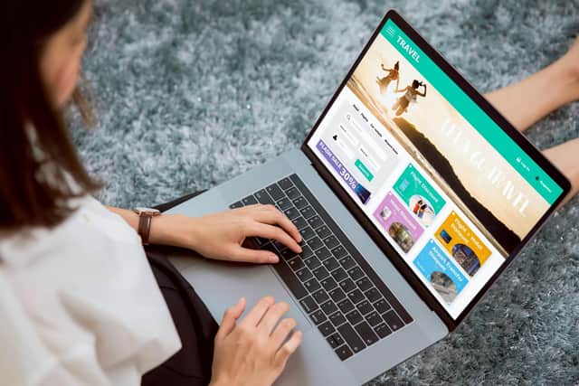 A lady sat with a laptop booking a holiday.