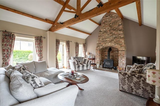 The living room displays a vaulted ceiling and an exposed brick fireplace with cosy wood-burning stove.