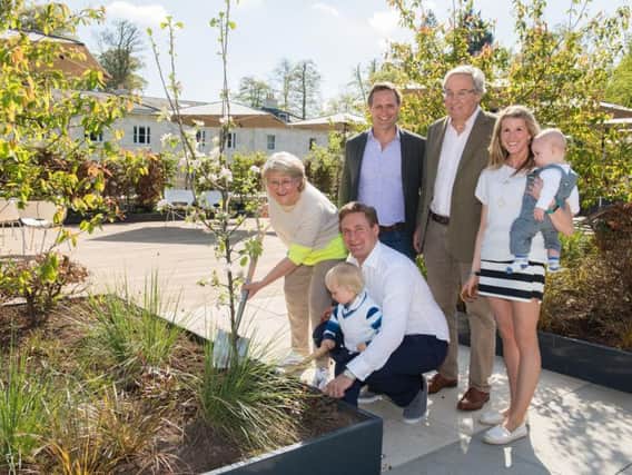 The Mackaness family plant an apple tree in the rooftop garden to celebrate the spa launch. Picture: Tim Hardy