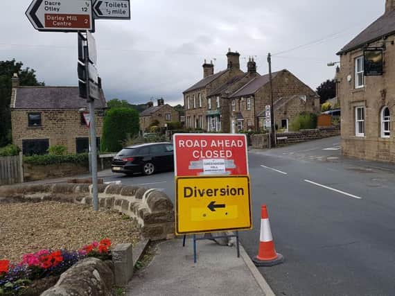 The 'road closed ahead' signs outside the Flying Dutchman pub in Summerbridge  with a handwritten bit added by residents making it clear Pateley Bridge is still open for business.