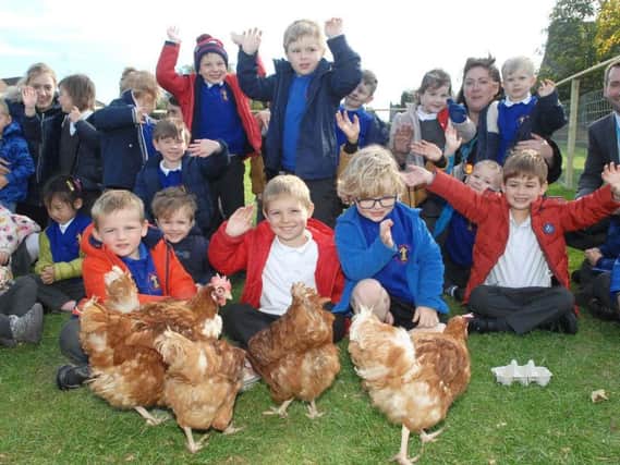 Headteacher Robert Mold with pupils at the community farm, celebrating the school's glowing Ofsted report.