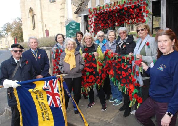 NAWN 1810234AM1 Thorner Church poppies. Founder of the Thorner Craft Group Carolyn Wildgoose with group members, RBL standard bearer John Wilson and David Fryer chairman of the Thorner branch of the Royal British Legion outside St Peters church. (1810234AM1)
