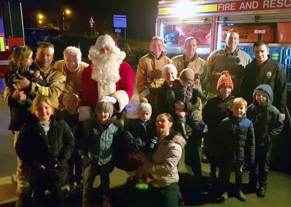 Santa is pictured with the Summerbridge Retained Firefighters and children at the late night opening event.