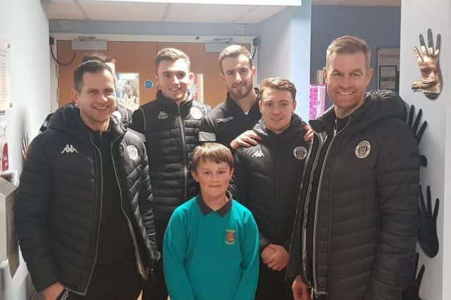 Paul Thirlwell, Toby Lees, James Belshaw, Jack Emmett and Simon Weaver with Toby, a young boy who loves football and was in the outpatients section