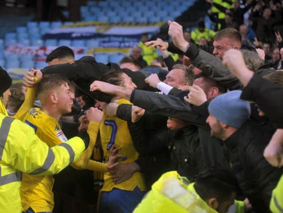 Leeds captain Luke Ayling and Jack Clarke dive into the fans to celebrate Kemar Roofe's late late winner. Picture Tony Johnson.