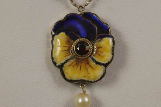 A champleve enamelled pansy pendant.