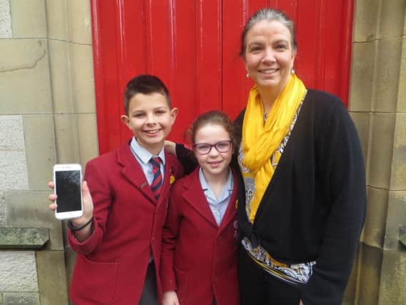 Mrs Richards is pictured with her two children Brady, 10, and Jordan, 8, outside the front door at Belmont Grosvenor School.