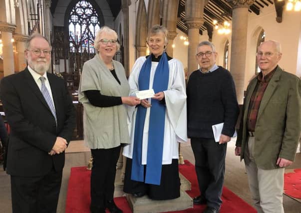 Jane Burniston, Nidderdale Messiah chair, (second left) presents the cheque to the church wardens.