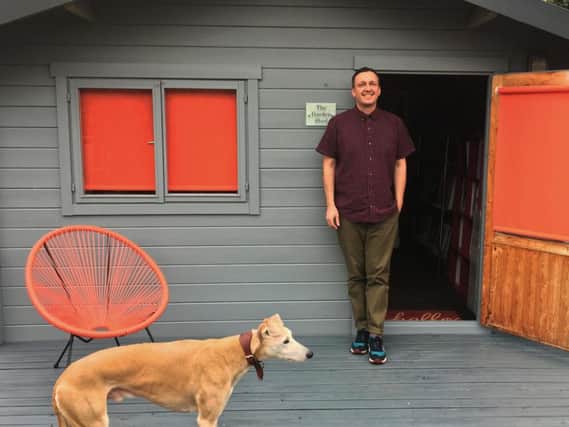 Versatile creative art director Andy Cole outside his shed in Knaresborough with his dog Toby.