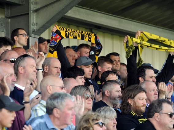 Harrogate Town supporters cheer on their team at the CNG Stadium.