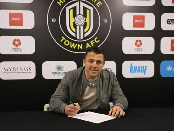 Scott Brown puts pen to paper on his deal with Harrogate Town. Picture: Matt Kirkham