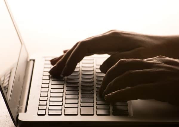 A woman's hands on a laptop keyboard.