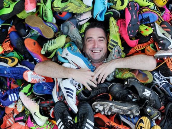 Paul Barker with just some of the football boots he collected, thanks to the generosity of Harrogate residents. Picture: Gerard Binks.