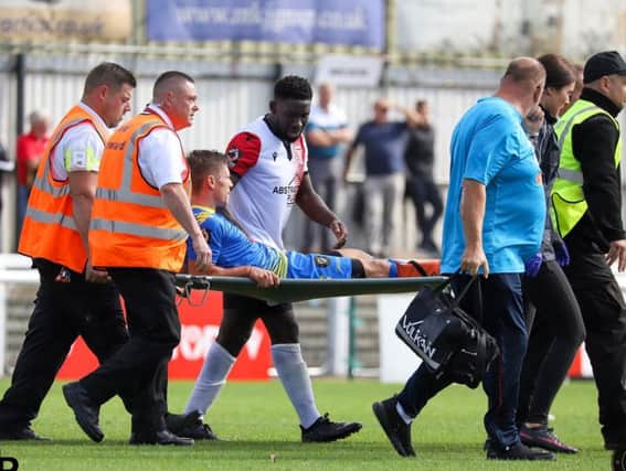 Harrogate Town midfielder Lloyd Kerry leaves the field on a stretcher at Woking. Picture: Matt Kirkham