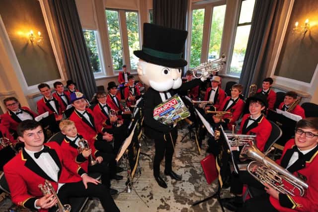 Mr Monopoly holding the new Harrogate edition of the boardgame whilst performing with the Tewit Youth Band.