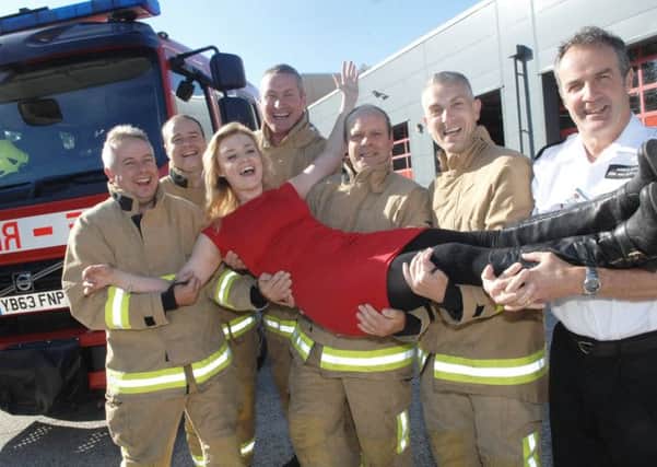 1408022AM2 Lucy Morgan at Fire Station.  Lucy Morgan who will host the fire station's open day on Sept 14th. with fire fighters Paul Swires, Rich Whiteley, Ian Anderson, Jess Bradley-Smith, Darran Smith and watch manager John Harvey (1408022AM2)