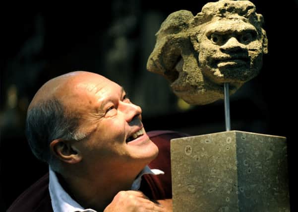 Paul Beedham looking at a medieval grotesque from limestone found in Petworth West Sussex c1450 on sale for £4,000 at the Harrogate Antiques Fair. (GL100368a)