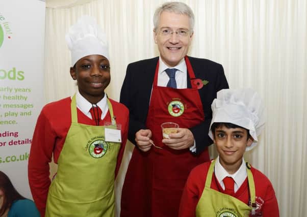 Schoolchildren at the PhunkyFoods 10th anniversary event in the Houses of Parliament showing Andrew Jones MP how to make SuperCrunch, a tasty, healthy snack.
