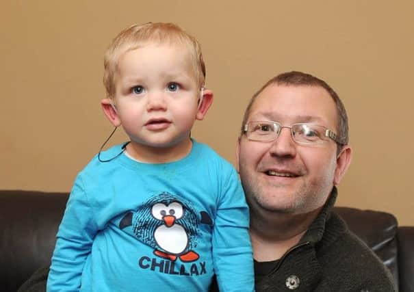 Date:7th January 2015, Picture James Hardisty, (JH1006/72e) Lucas Carruthers, (correct) 16 months, of St Andrews Walk, Harrogate, is able to hear for the first time thanks to a hearing aid implanted at Bradford Royal Infirmary his brother Hayden had the same operation whenhe was younger, pictured with his dad Scot, (correct) aged 42.